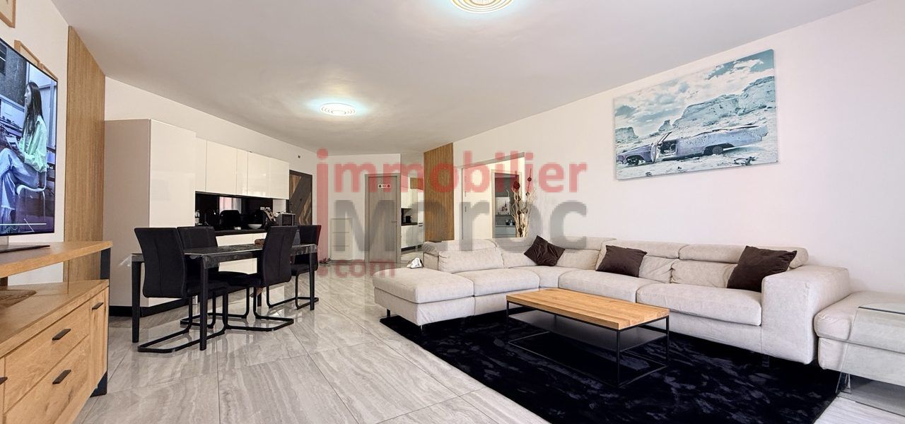 Vue du salon avec canapé d'angle et coin salle à manger – appartement meublé à louer à Marrakech, Samlalia