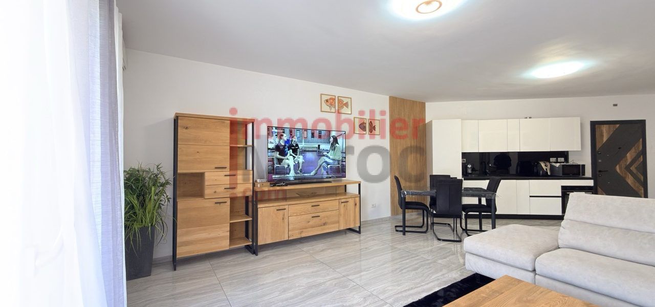 Salon ouvert avec meuble TV, coin repas et cuisine équipée – appartement à louer à Marrakech, Samlalia