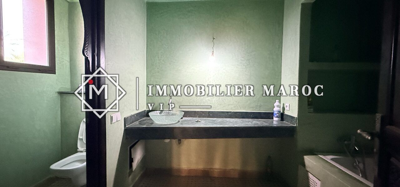 Salle de bain en tadelakt vert avec baignoire et vasque – suite à la Palmeraie de Marrakech